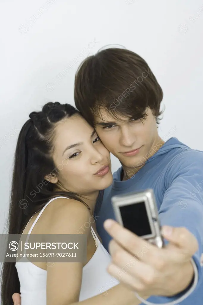 Young couple taking self portrait with digital camera