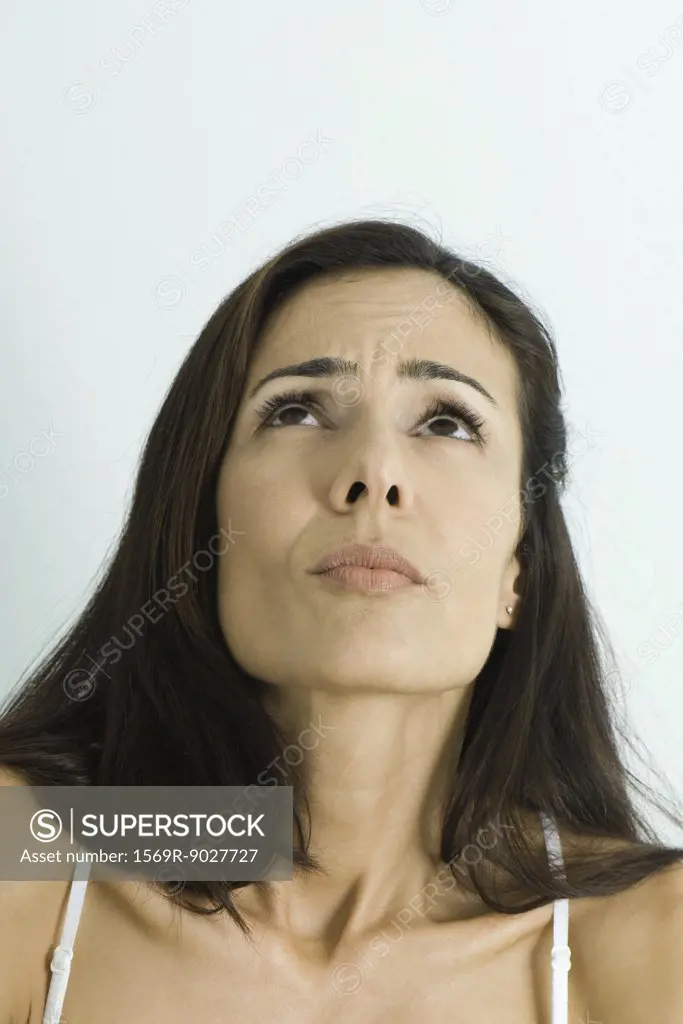 Woman cringing, looking up, portrait