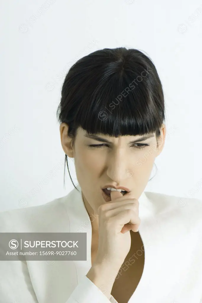 Well-dressed young businesswoman biting thumb, portrait