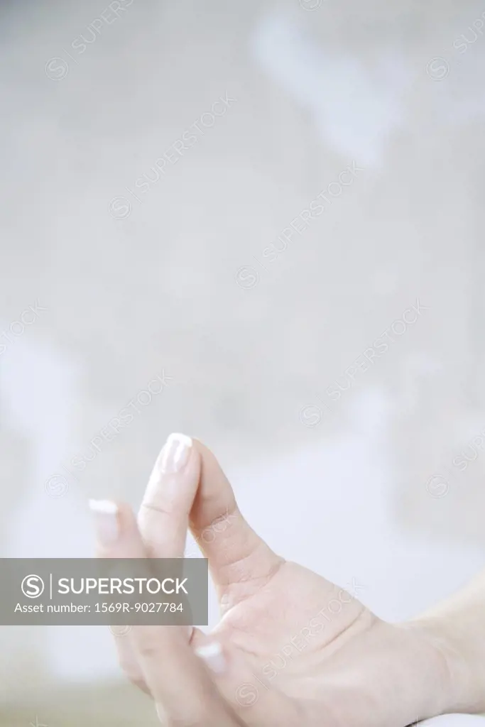 Cropped view of woman's hand, forefinger touching thumb