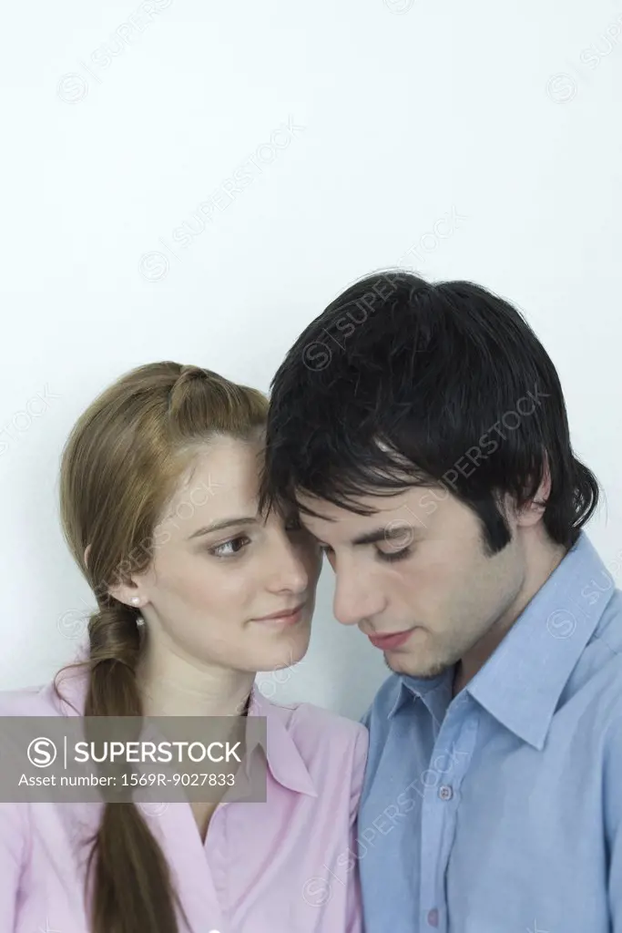 Young couple with heads close together, portrait