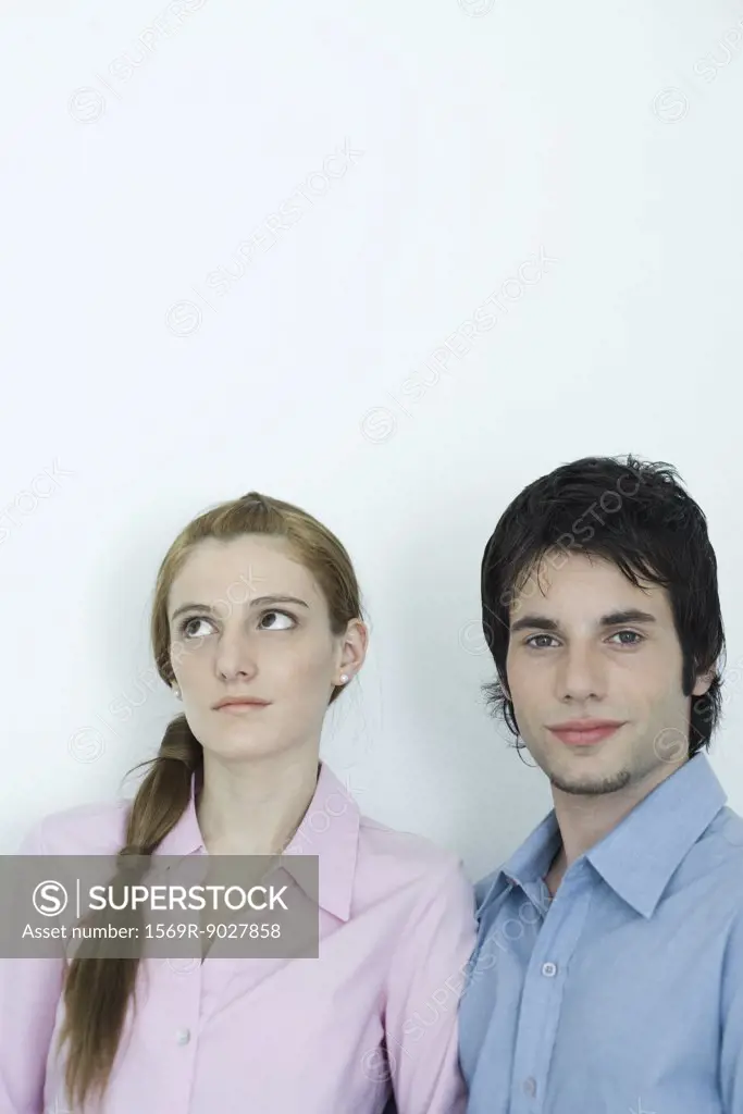 Young couple, man looking at camera while woman looks away, portrait