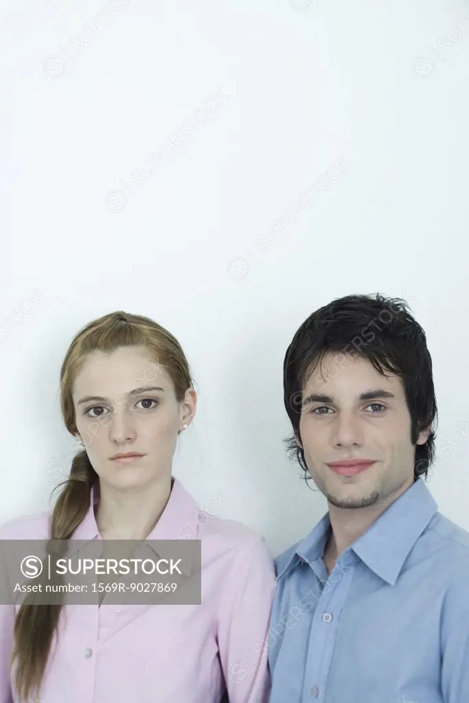 Young couple looking at camera, head and shoulders, portrait