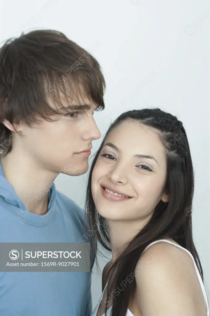 Young couple, woman leaning against man, smiling at camera,, portrait