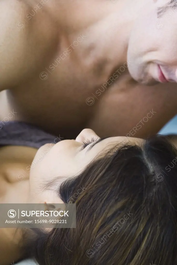 Man lying on top of woman, cropped view, close-up