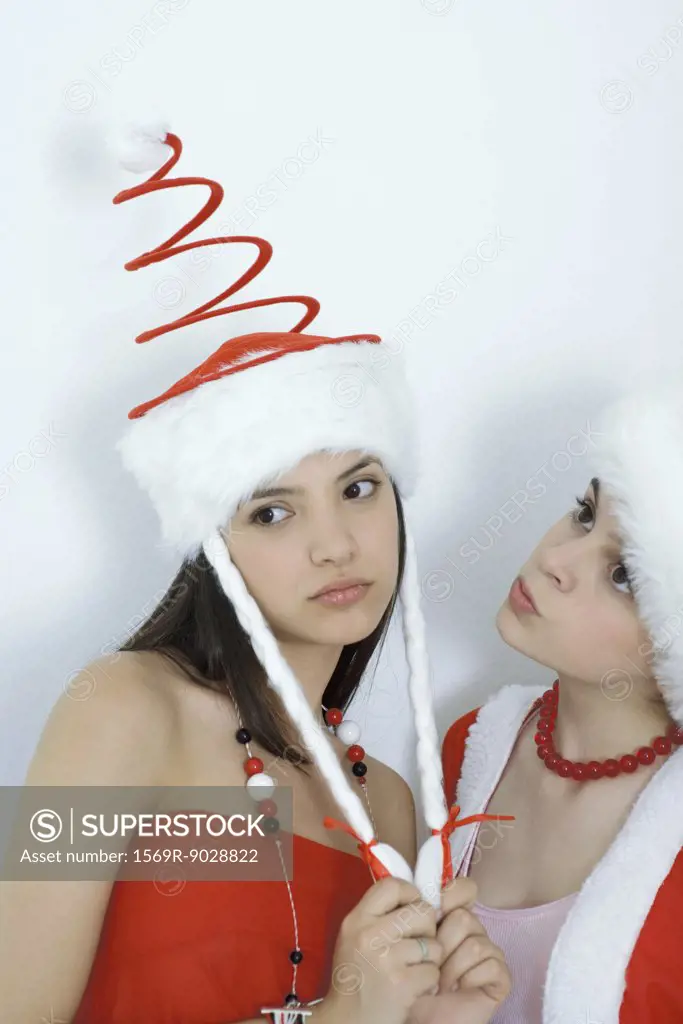 Two young female friends dressed in Christmas costumes, looking sad, portrait