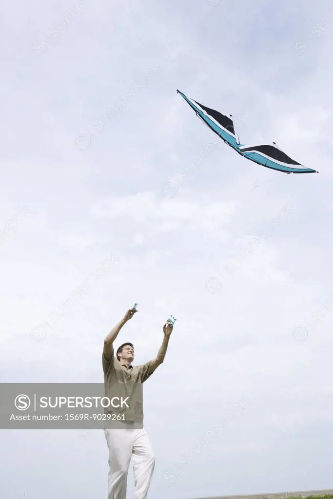 Man flying kite, low angle view