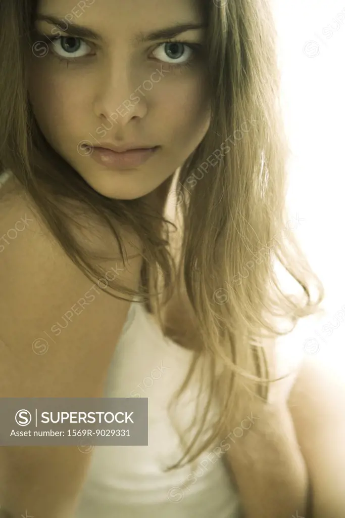 Young woman staring over shoulder at camera, cropped view