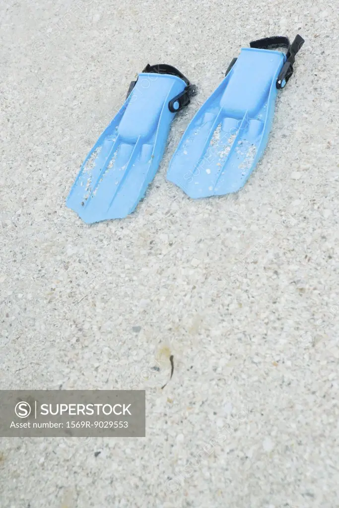 Plastic flippers on sand, close-up