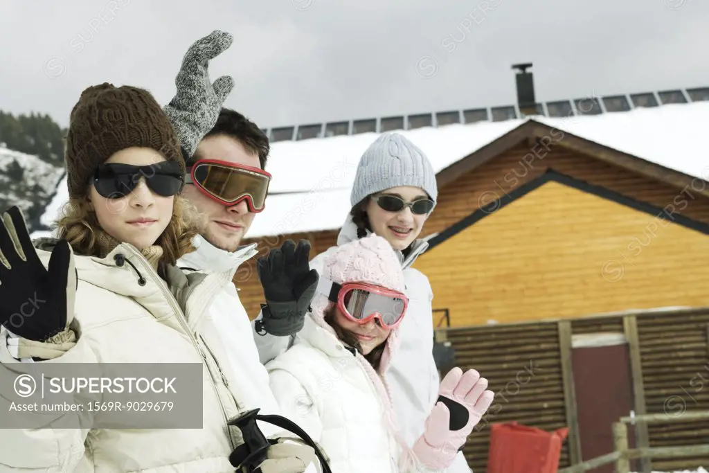 Group of young skiers waving at camera
