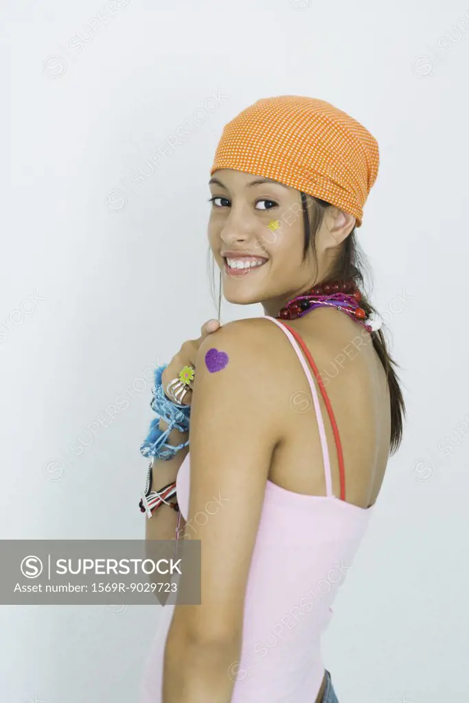 Teenage girl wearing bandana, smiling over shoulder at camera