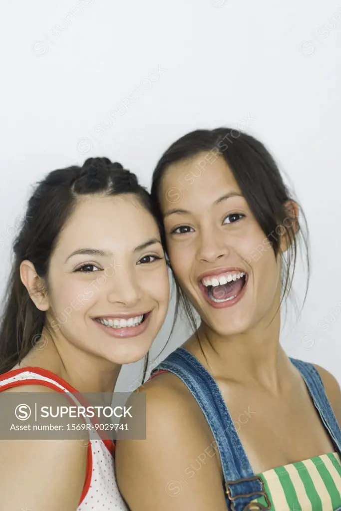 Two young friends smiling at camera, portrait