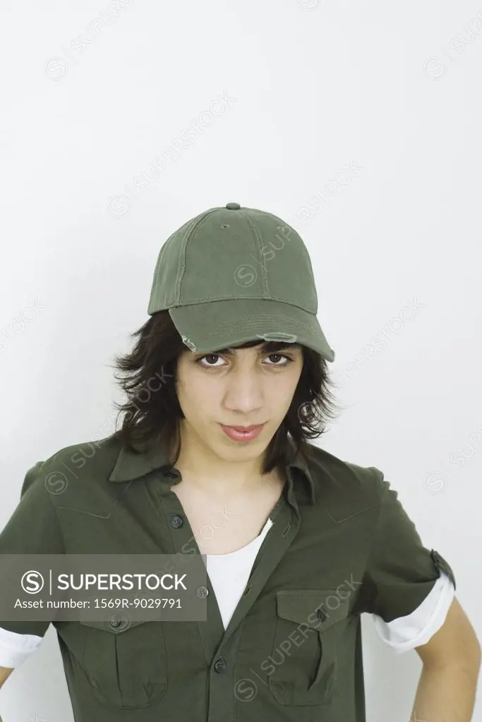 Teenage boy wearing baseball cap, looking at camera