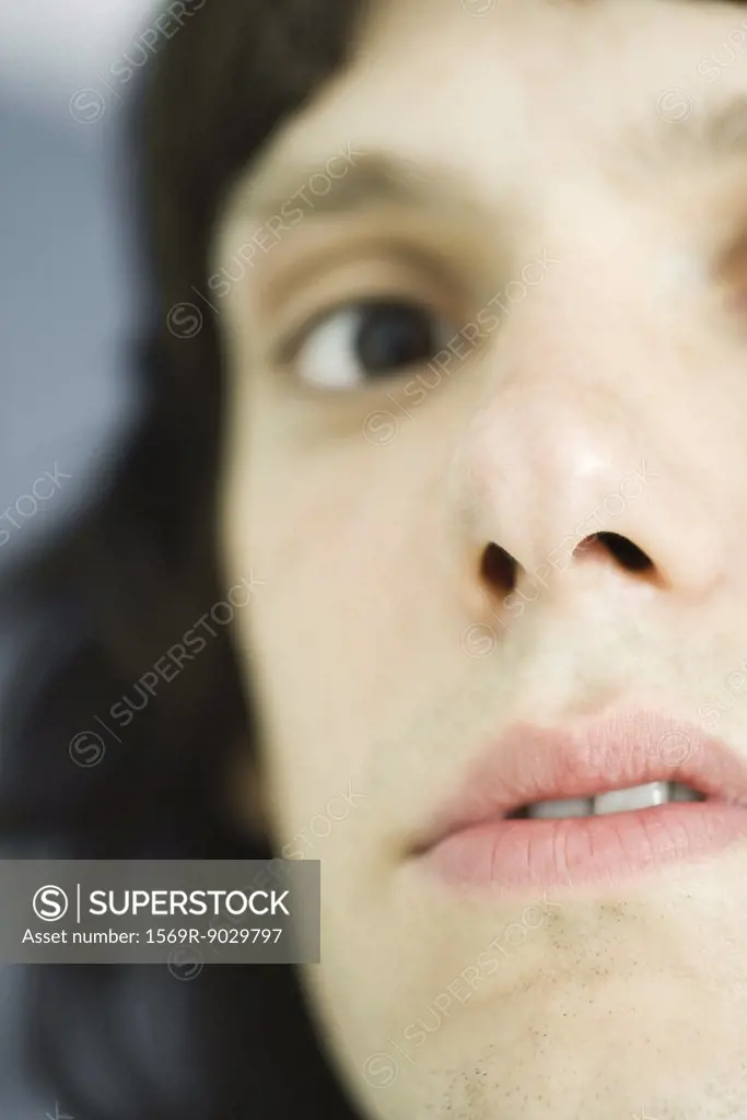 Teenage boy looking at camera, close-up, cropped view