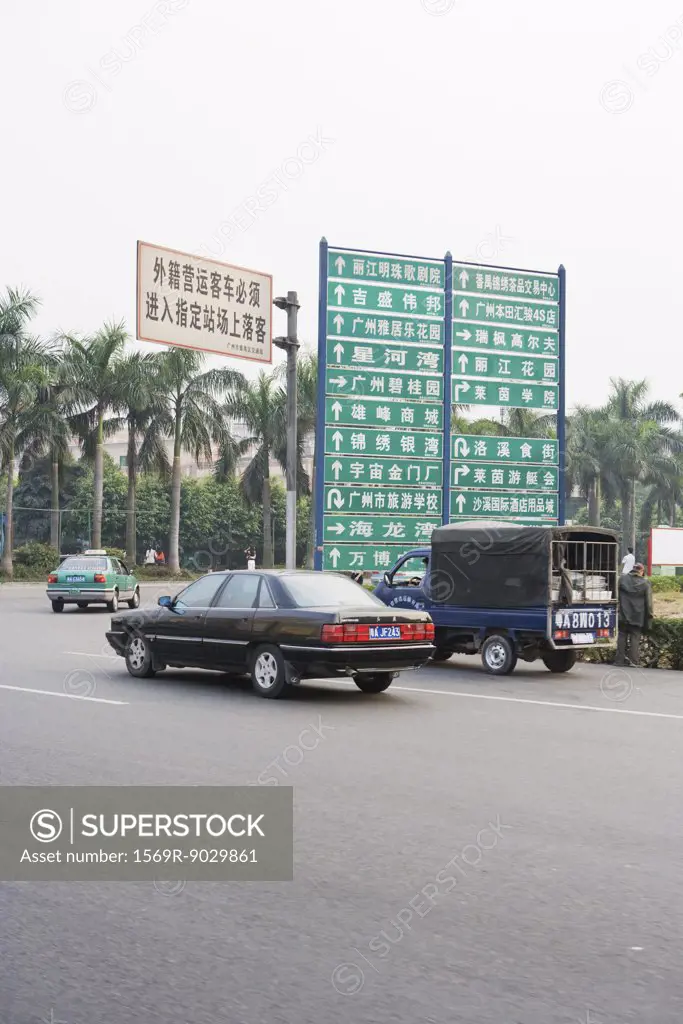 China, cars turning by directional signs