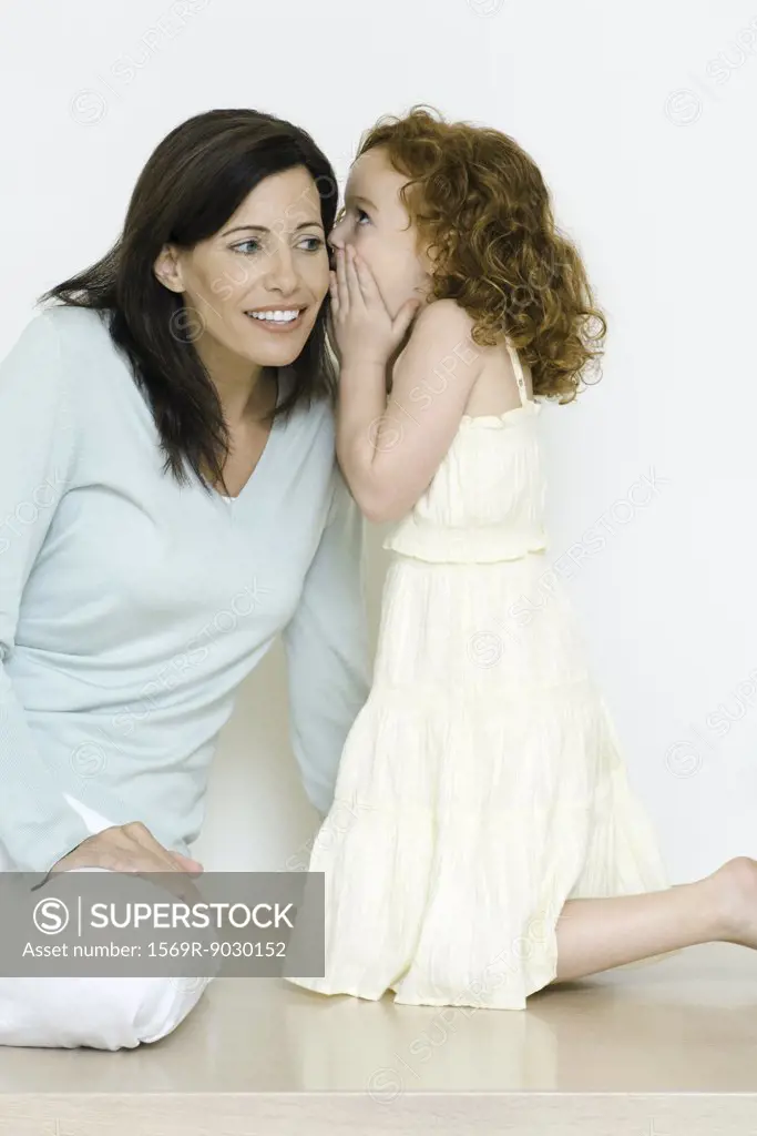 Little girl whispering to mother