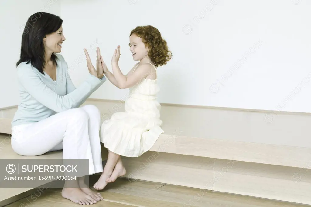 Little girl playing clapping game with mother