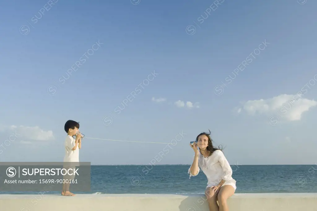 Boy and young woman using tin can phones