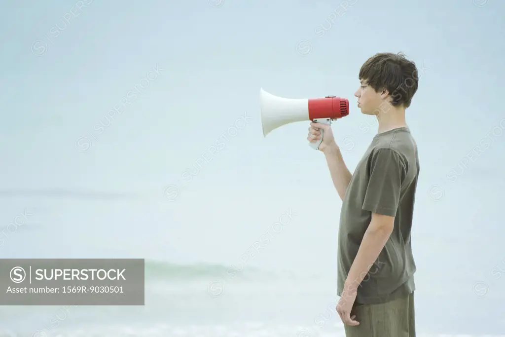 Boy using megaphone, side view