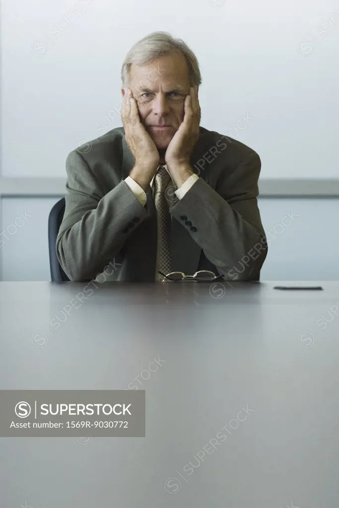 Businessman sitting with head in hands, looking down