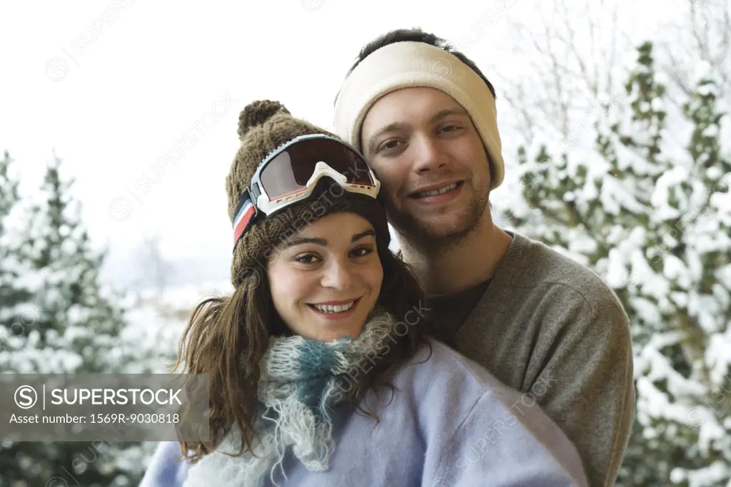 Young couple in winter clothes, smiling at camera, portrait
