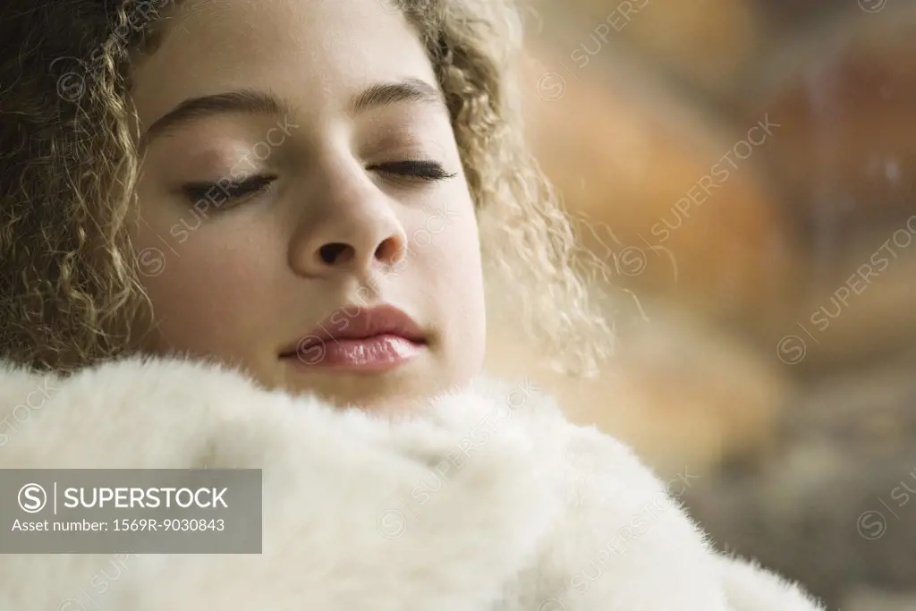 Teen girl sleeping under soft blanket, close-up