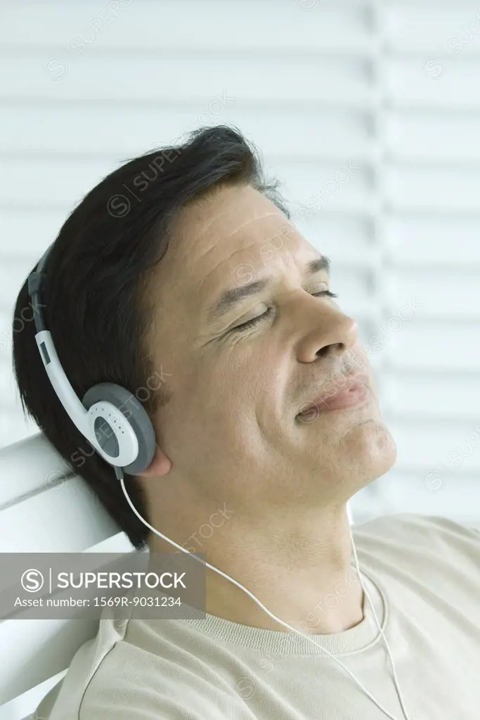 Man listening to headphones, smiling, eyes closed
