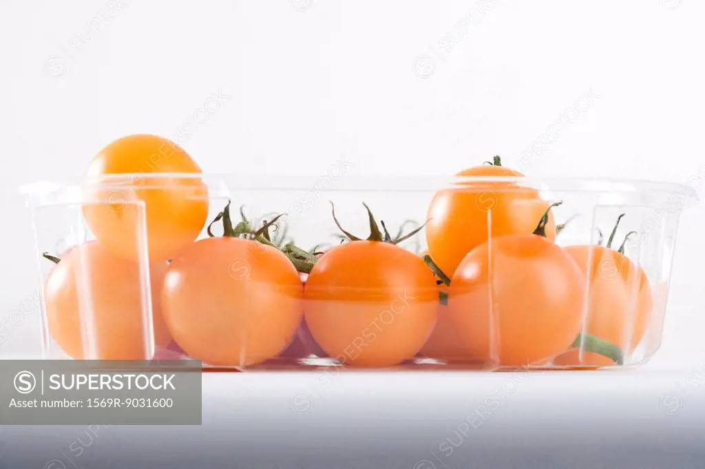 Yellow vine tomatoes in plastic container, close-up