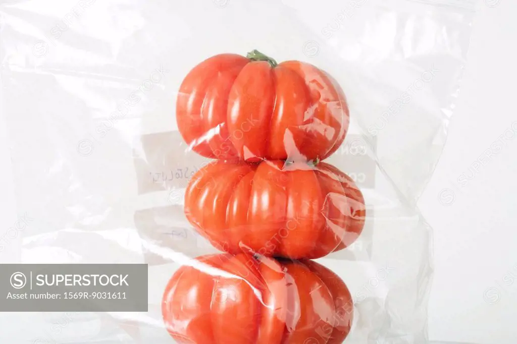 Heirloom tomatoes stacked in plastic bag, close-up