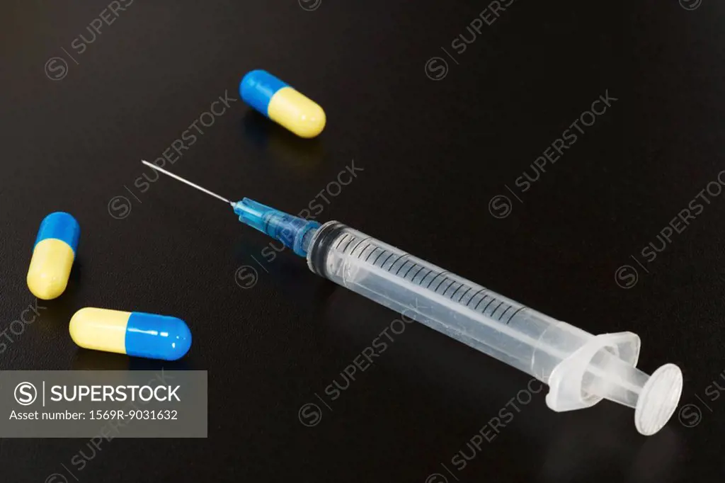 Syringe and capsules, close-up