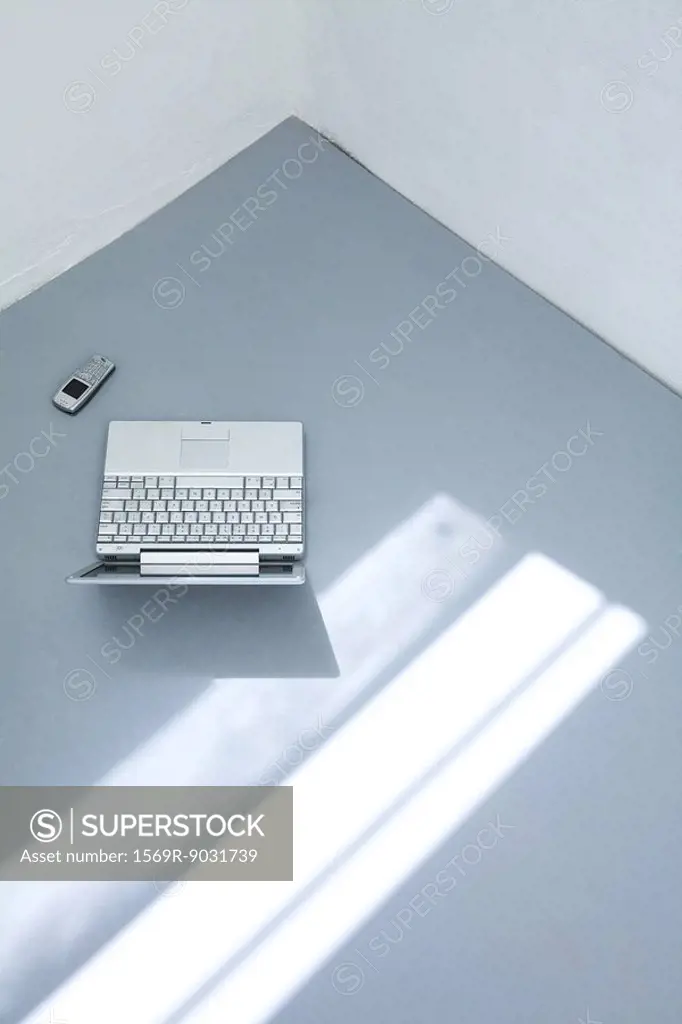 Laptop computer and cell phone on the ground, high angle view