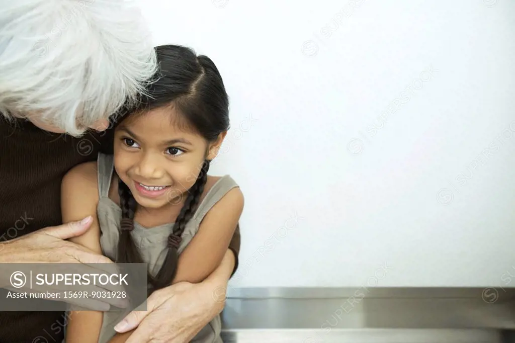 Grandmother embracing granddaughter, close-up
