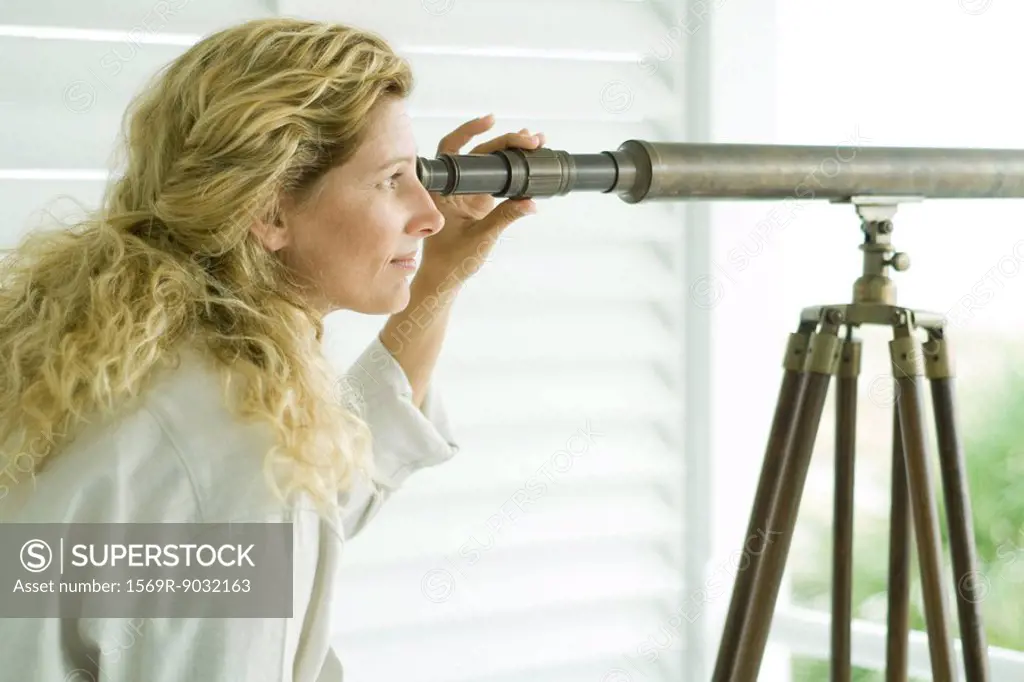 Woman looking through telescope, side view