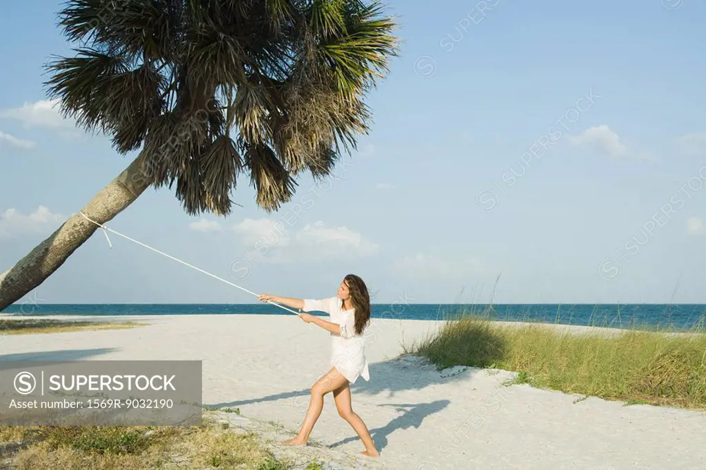 Woman pulling palm tree with rope