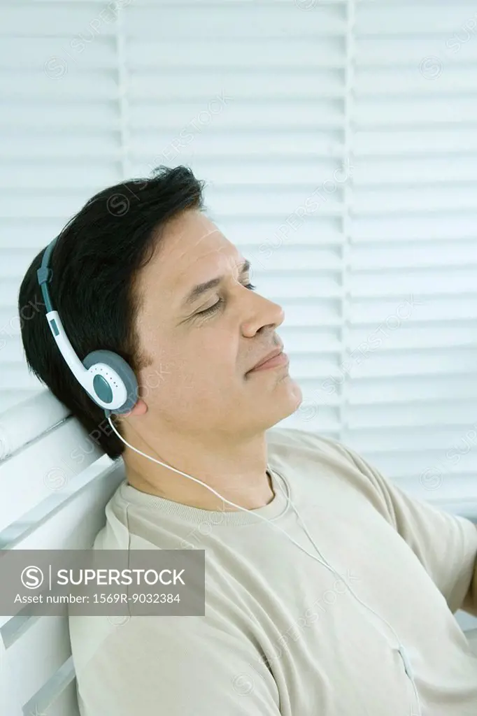 Man listening to headphones, eyes closed, side view