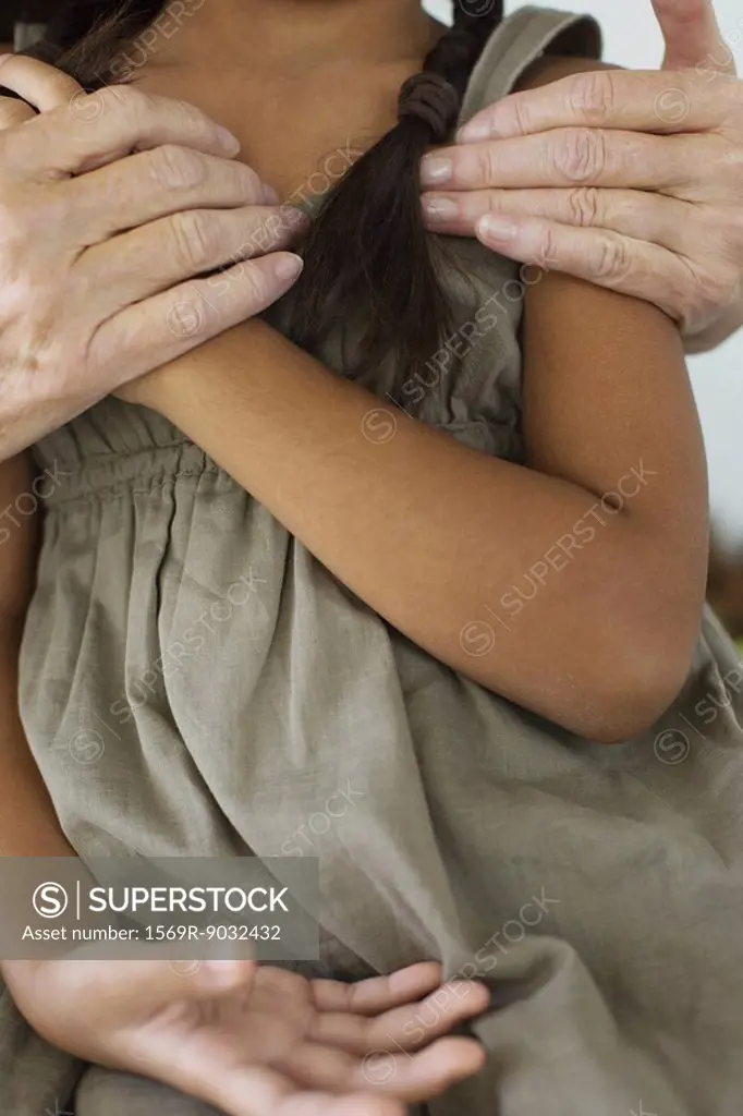 Woman embracing little girl, close-up, cropped view