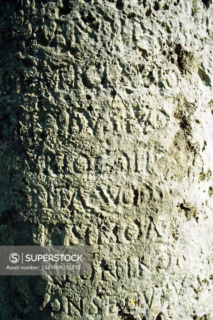 Text carved in stone, close-up, full frame