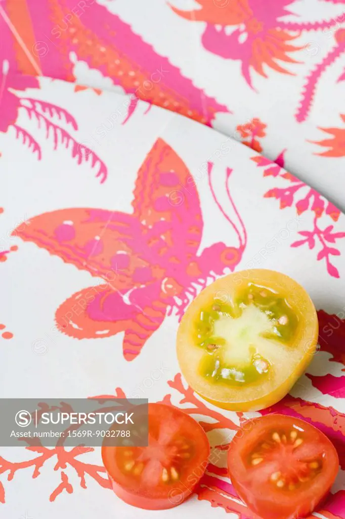 Red and yellow tomato slices on colorful plate, close-up