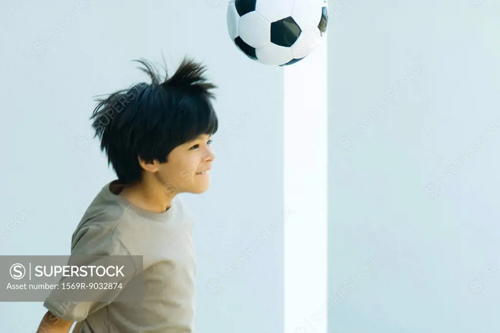 Boy playing with soccer ball, side view