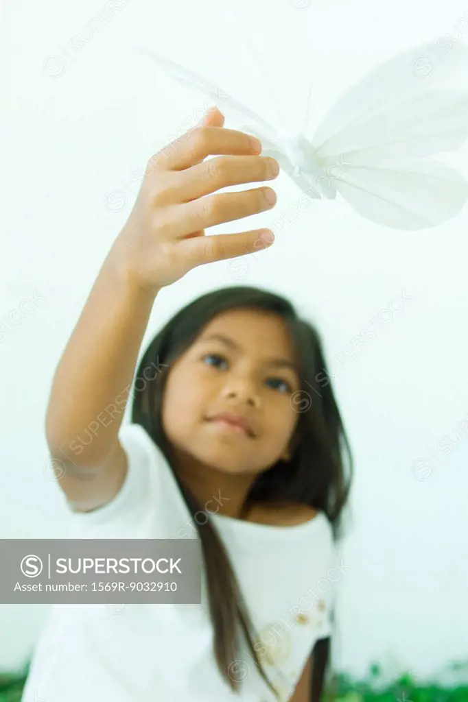 Little girl touching butterfly, low angle view