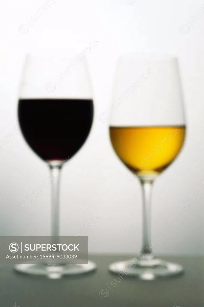 Two wine glasses with red and white wines, defocused