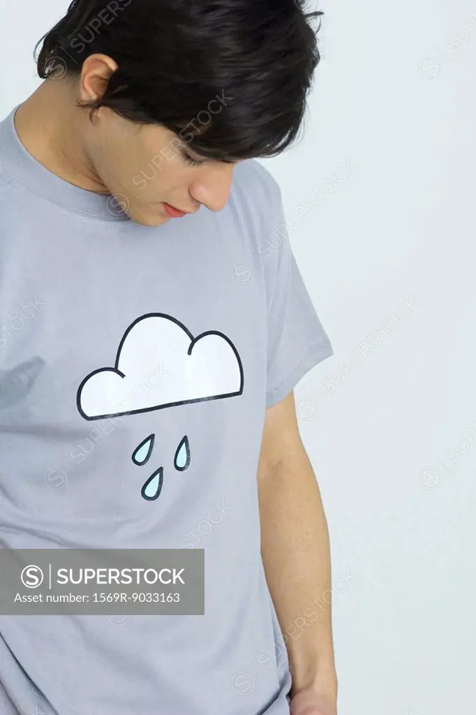 Young man wearing tee-shirt printed with cloud and raindrops, head down