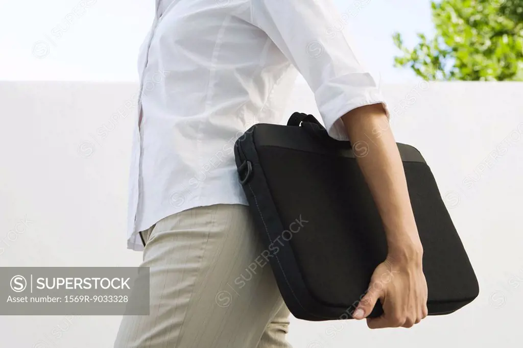 Woman carrying laptop bag, cropped view of mid section