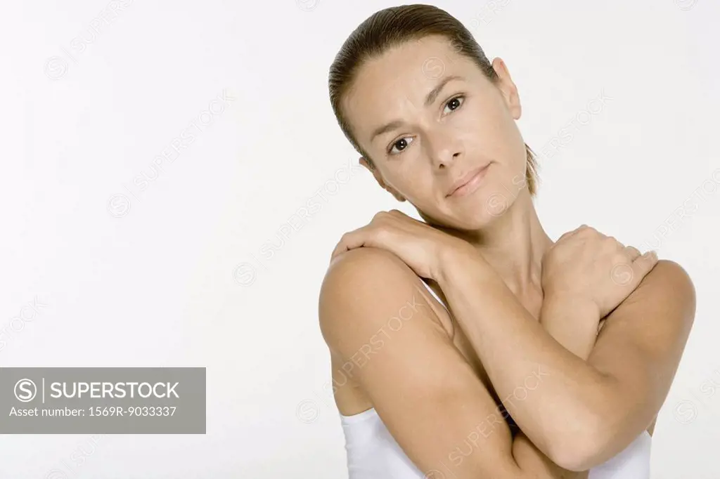 Woman folding arms across chest, looking at camera