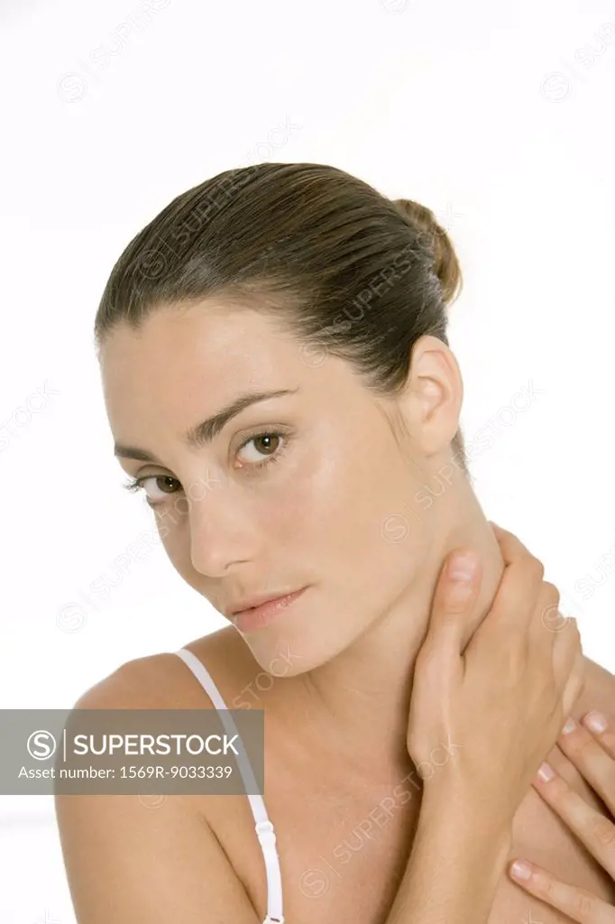 Woman holding neck, looking at camera