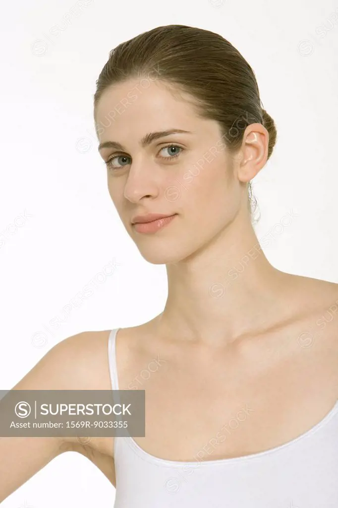 Woman with hair in bun, wearing white tank top, portrait
