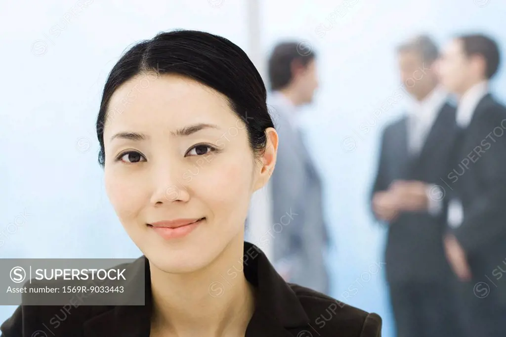 Businesswoman, portrait, colleagues standing in background