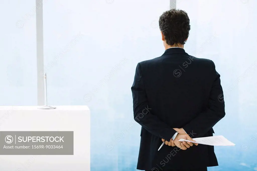 Businessman preparing to give speech, looking out of window