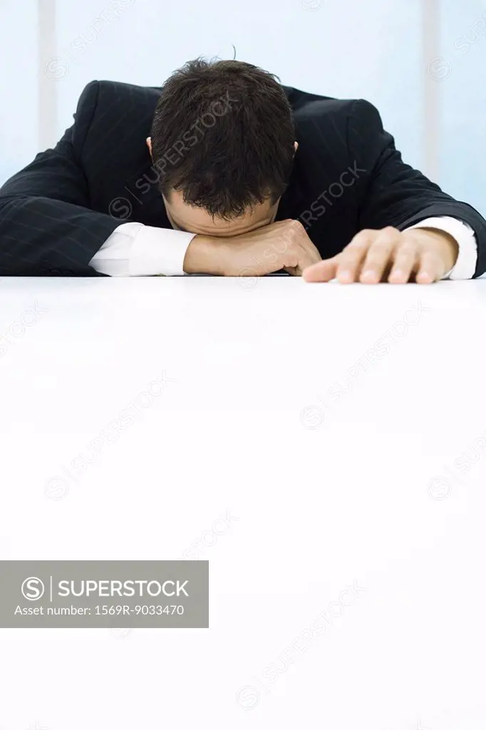 Businessman with head down on table