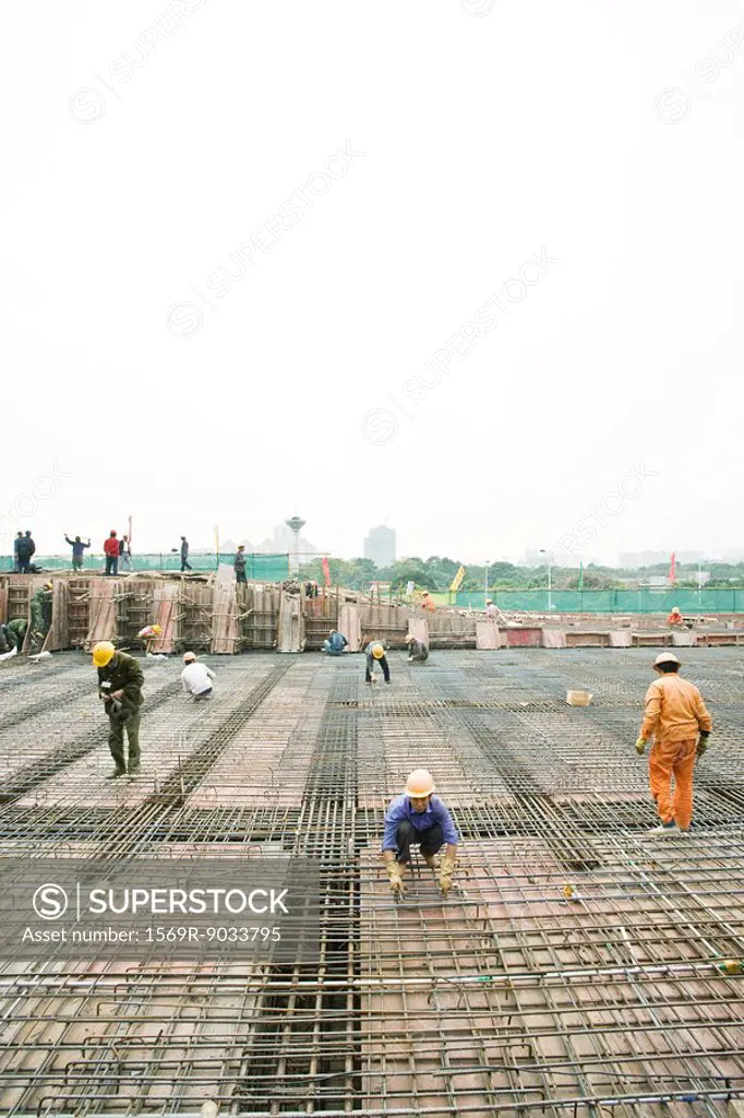 Workers building steel framework at construction site